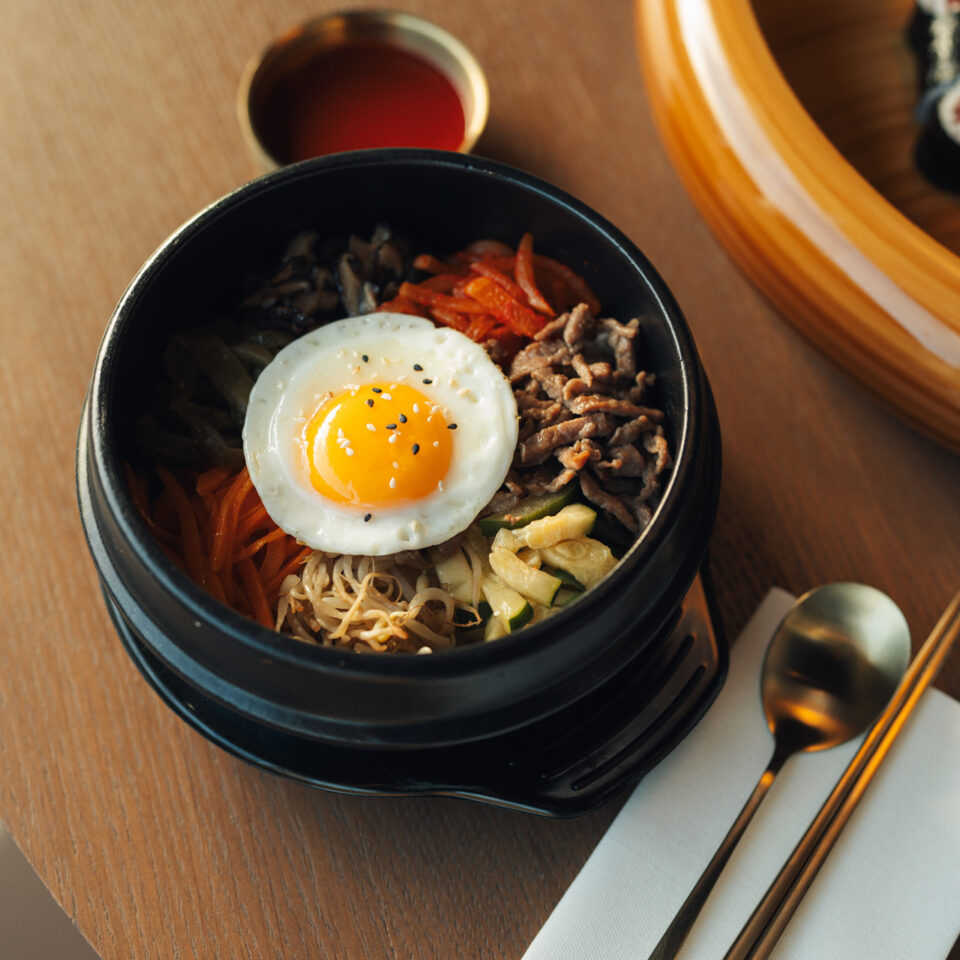 Korejské bibimbap s vejcem u stolu v han.sik